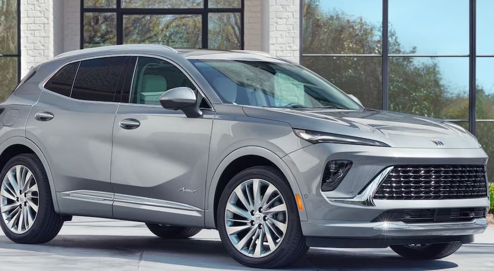 A silver 2024 Buick Envision is shown parked near a building.