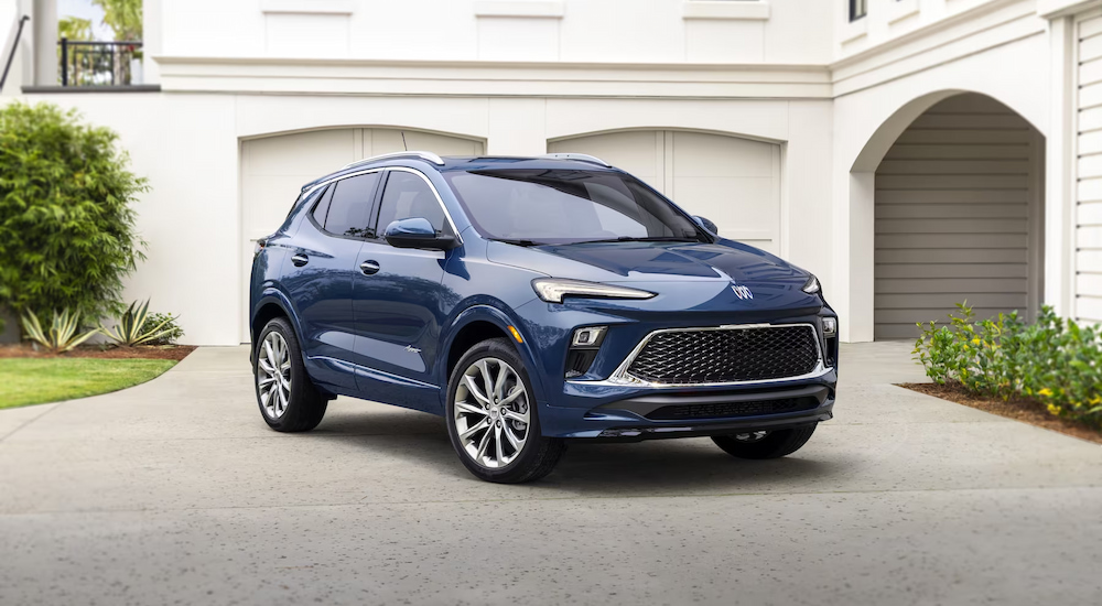 A blue 2024 Buick Encore GX Avenir parked in an open driveway.