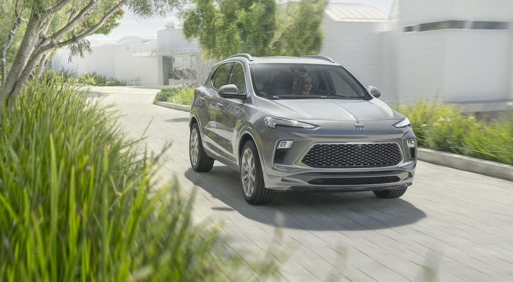A silver 2024 Buick Encore GX driving down a road.