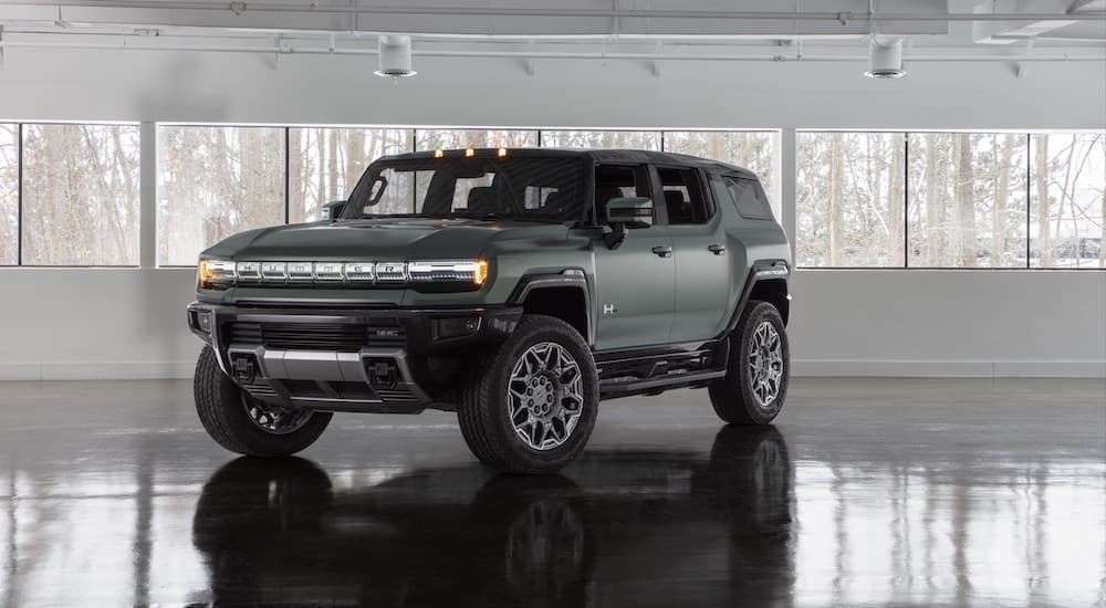 A green 2025 GMC Hummer EV SUV is shown from the front at an angle.