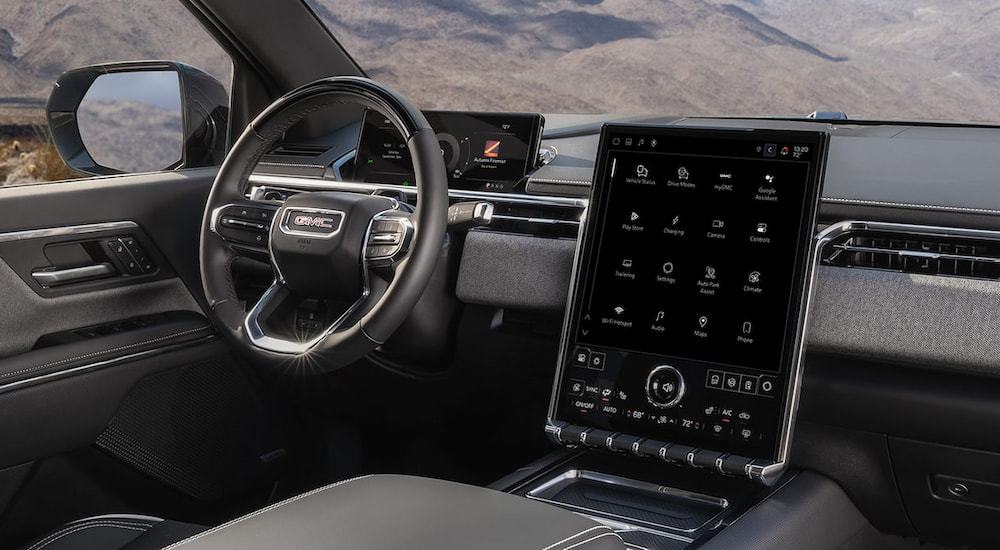 Steering wheel and dashboard screen inside a 2026 GMC Sierra EV Elevation.