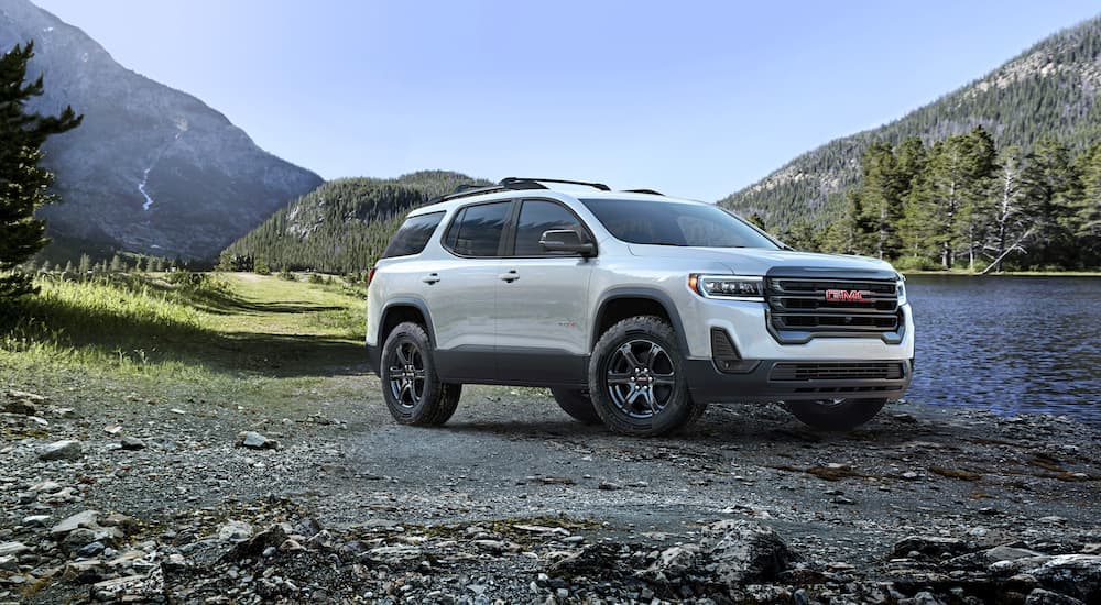 A white 2023 GMC Acadia AT4 parked off-road.