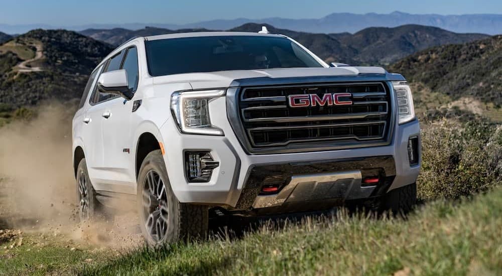 A white 2023 GMC Yukon AT4 off-roading.