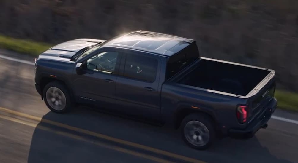 Aerial view of a gray 2027 GMC Sierra 1500 driving on a highway.