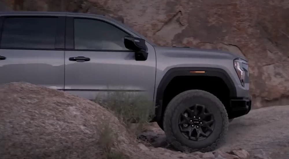 A gray 2027 GMC Sierra 1500 is parked off-road.
