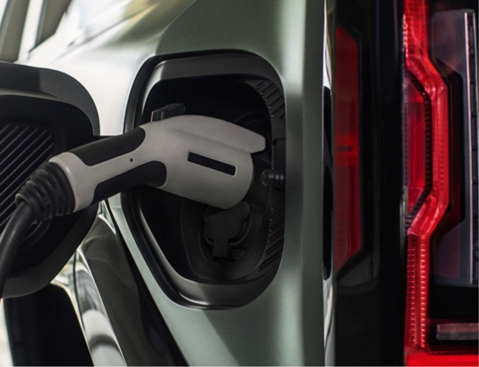 Close up of charging port with charger plugged in on a GMC Hummer EV SUV - LaFontaine Buick GMC Highland in Highland Charter Township MI