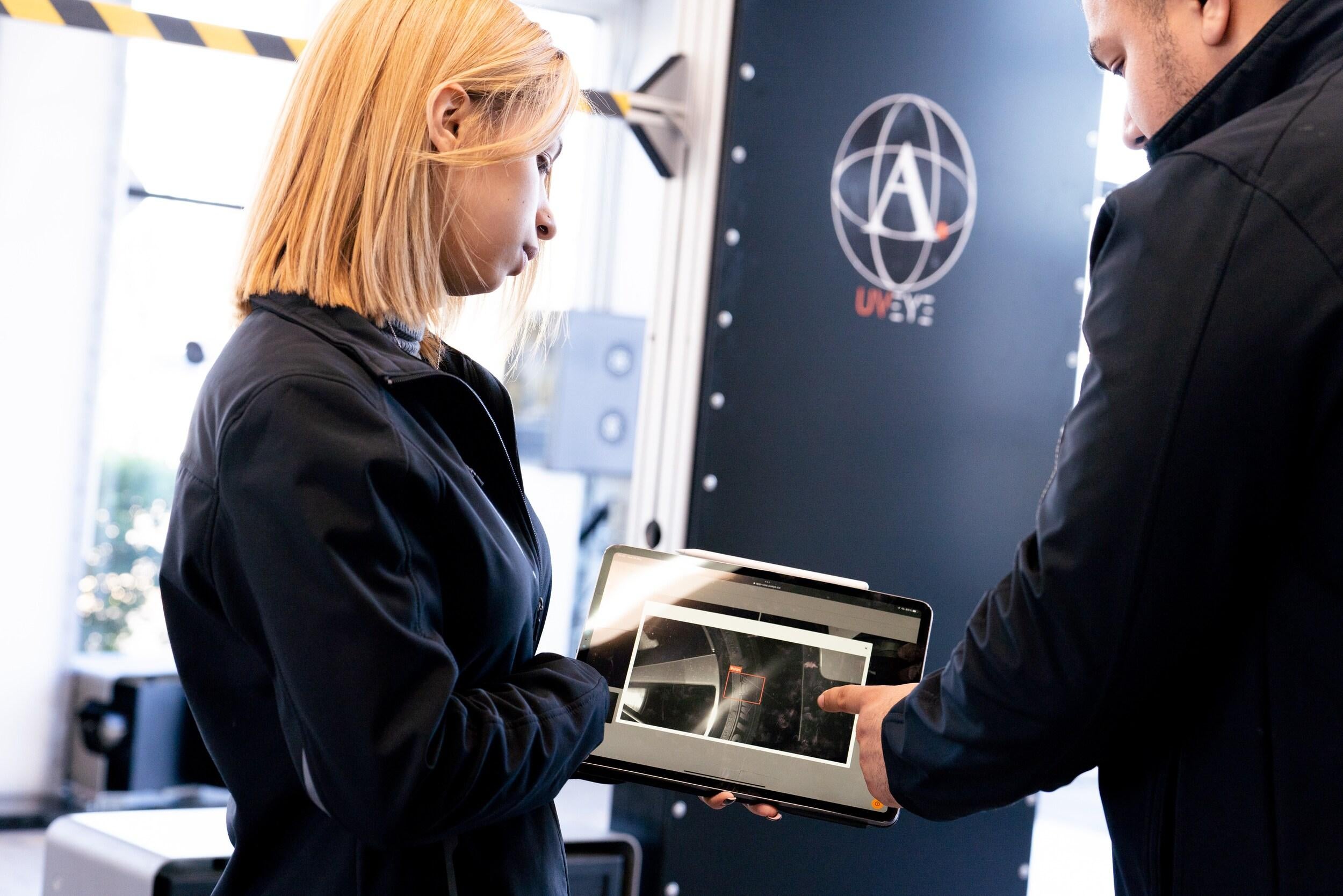 LaFontaine Service Advisor reviewing UVeye inspection tablet with customer