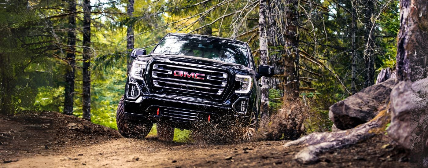 Black 2019 GMC Sierra 1500 driving through a forest.