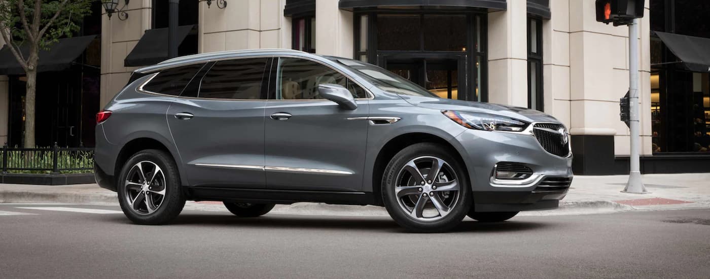 Grey 2021 Buick Enclave driving around a bend in a city.
