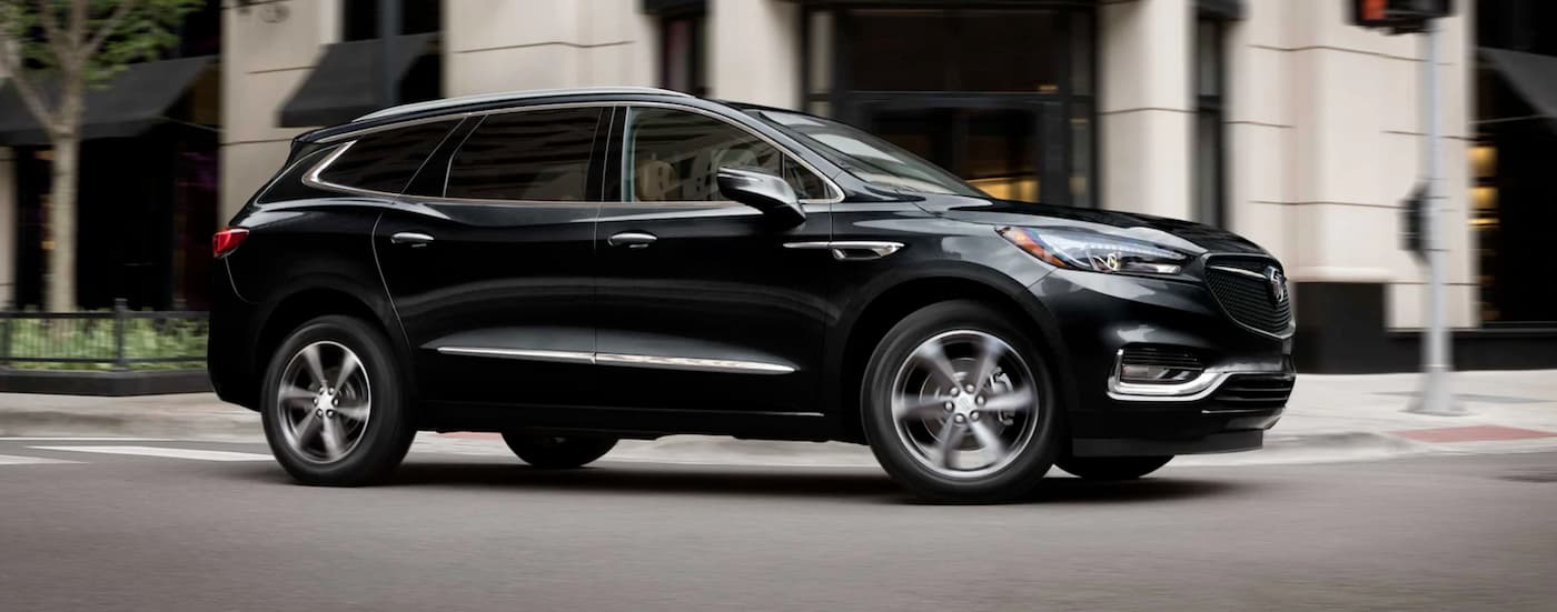 Black 2021 Buick Enclave driving through an intersection.