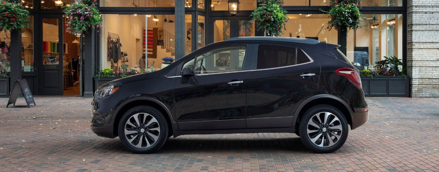 Side of a black 2022 Buick Encore parked in front a shop.