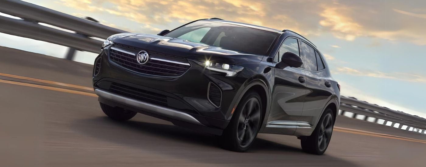 Black 2023 Buick Envision ST driving across a bridge.