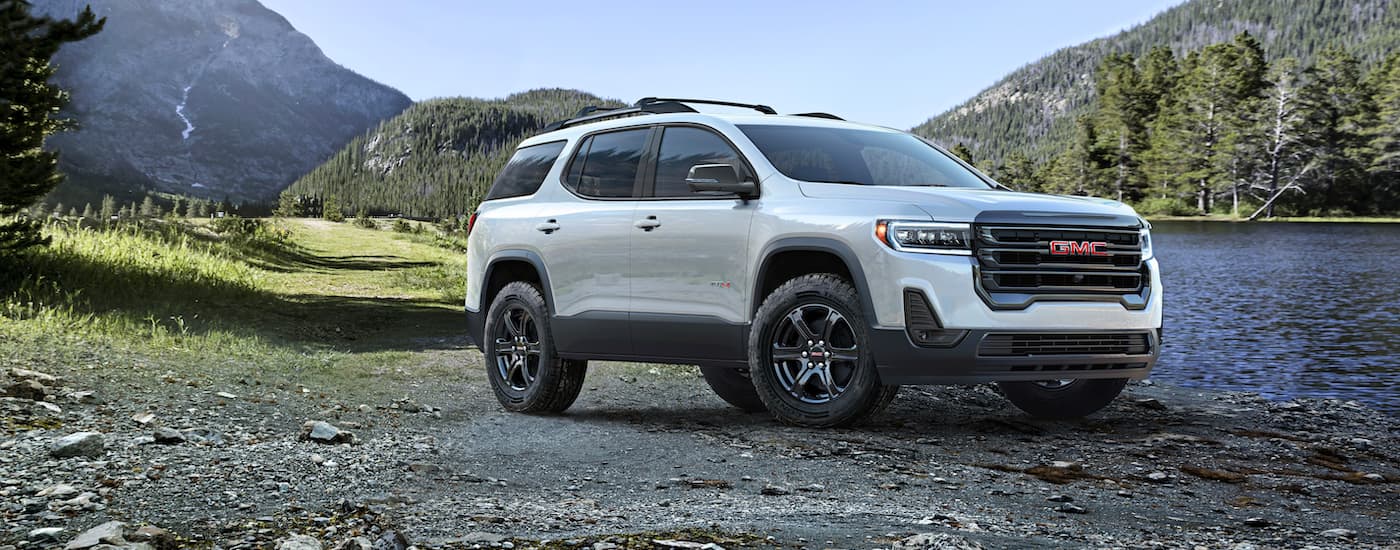 White 2023 GMC Acadia AT4 parked next to a body of water