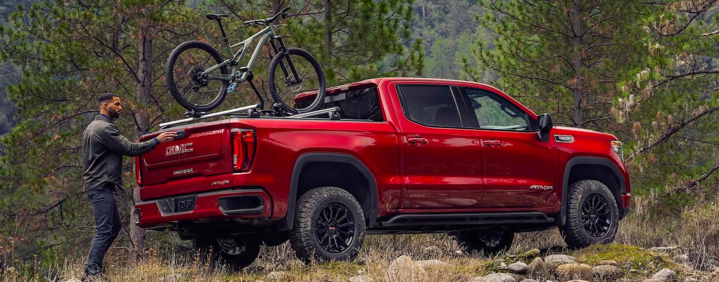 Rear of a red 2023 GMC Sierra 1500 AT4X parked off-road.