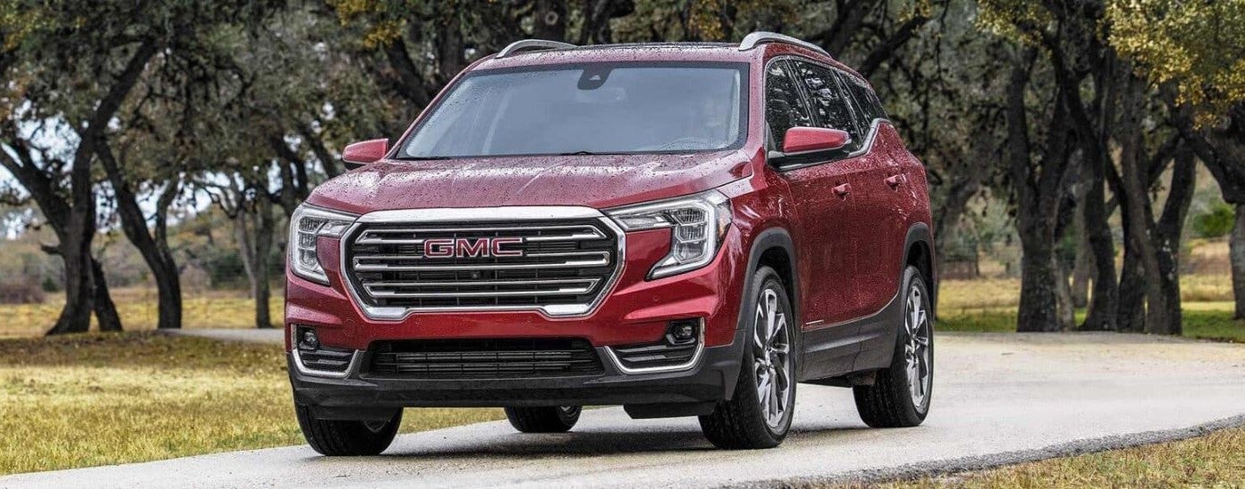 Red 2023 GMC Terrain SLT driving down a trail.