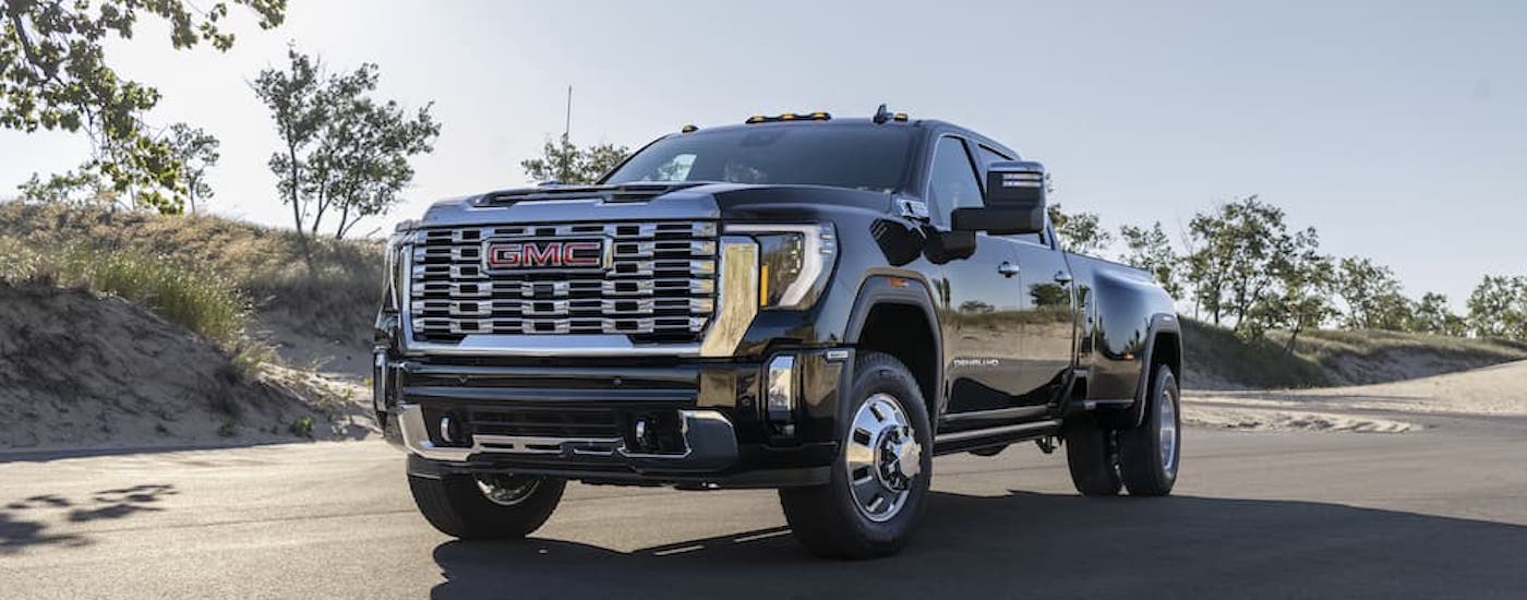 A black 2024 GMC Sierra 3500 HD Denali is shown from the front at an angle after leaving a GMC dealer.