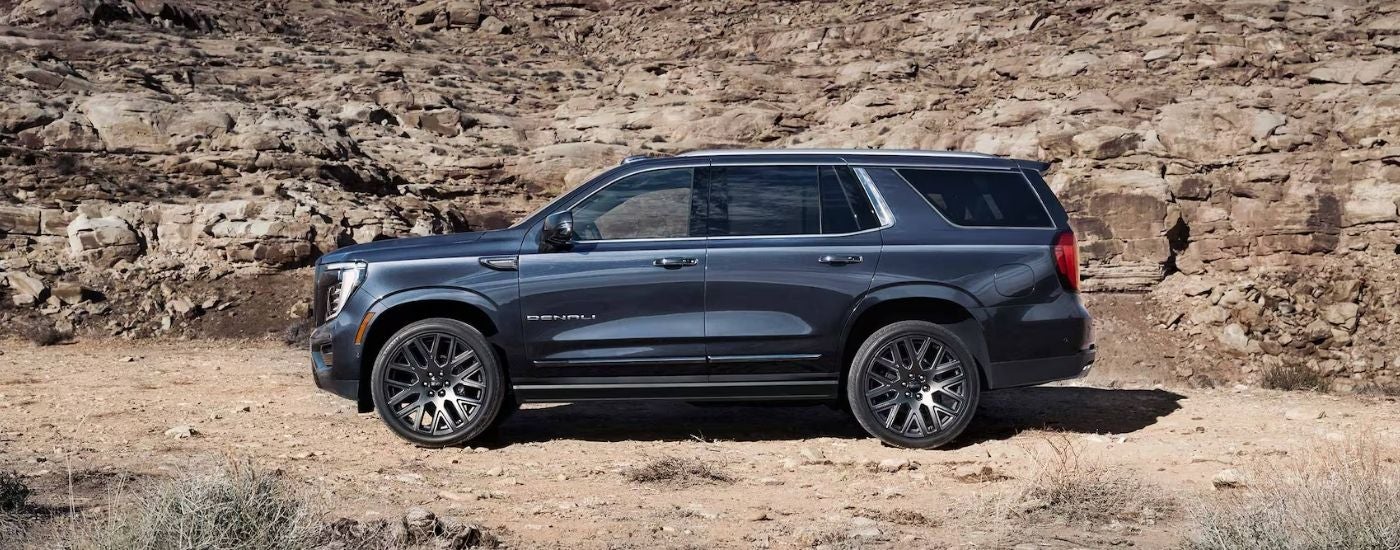 Side view of a black 2026 GMC Yukon XL parked off-road