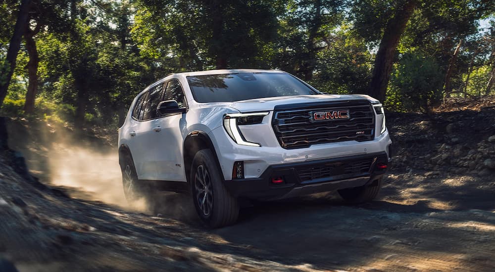 White 2026 GMC Acadia driving off-road.