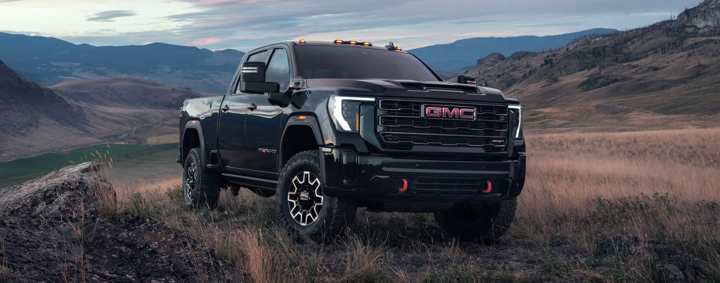 Black 2026 GMC Sierra 2500 HD AT4X parked off-road at an angle