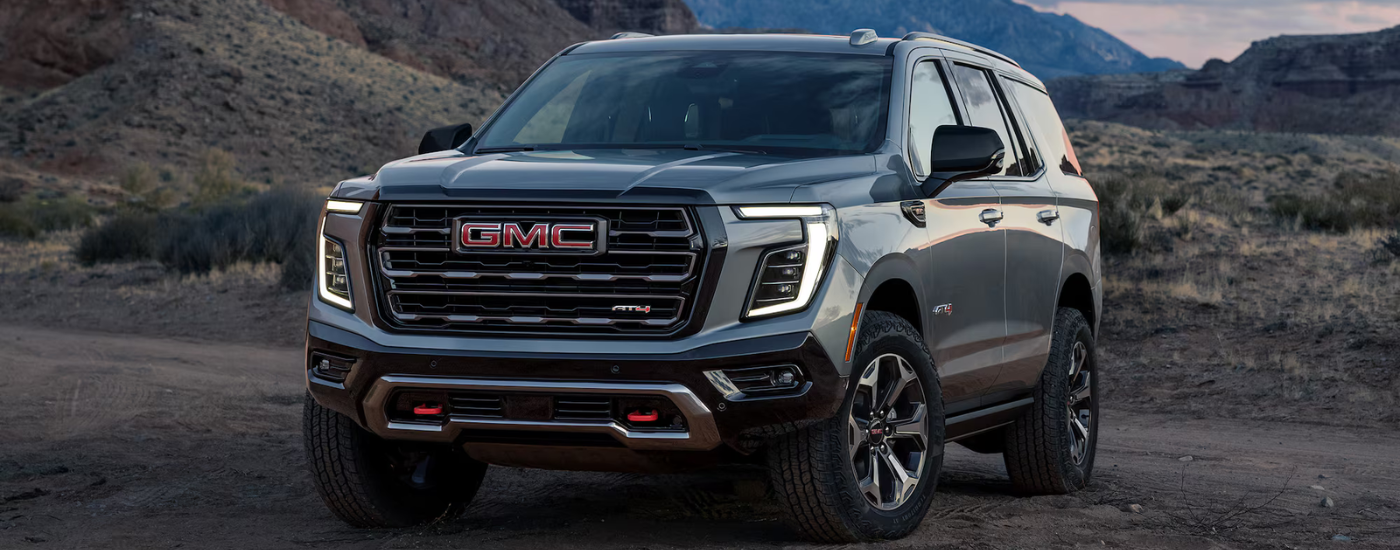 Black 2026 GMC Yukon XL AT4 parked off-road at an angle
