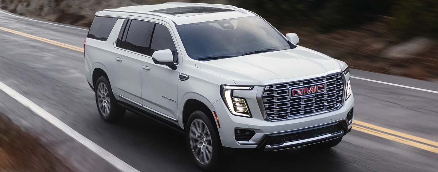 White 2026 GMC Yukon driving down an open road