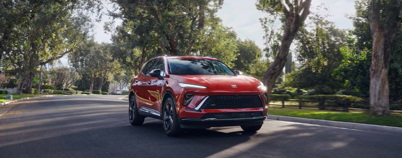 Red 2026 Buick Envision driving on a residential street.