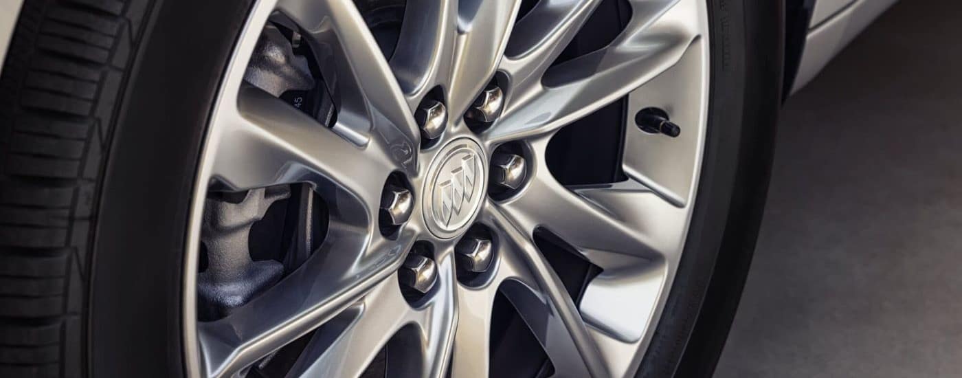 A close-up on the wheel of a 2024 Buick Enclave Avenir is shown.