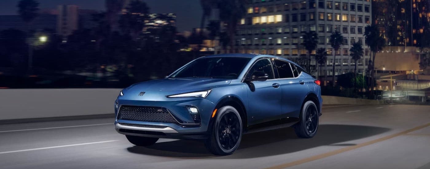 A blue 2026 Buick Envista ST driving near a city.