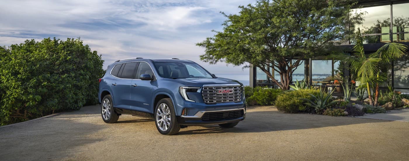 A blue 2026 GMC Acadia parked on a driveway.