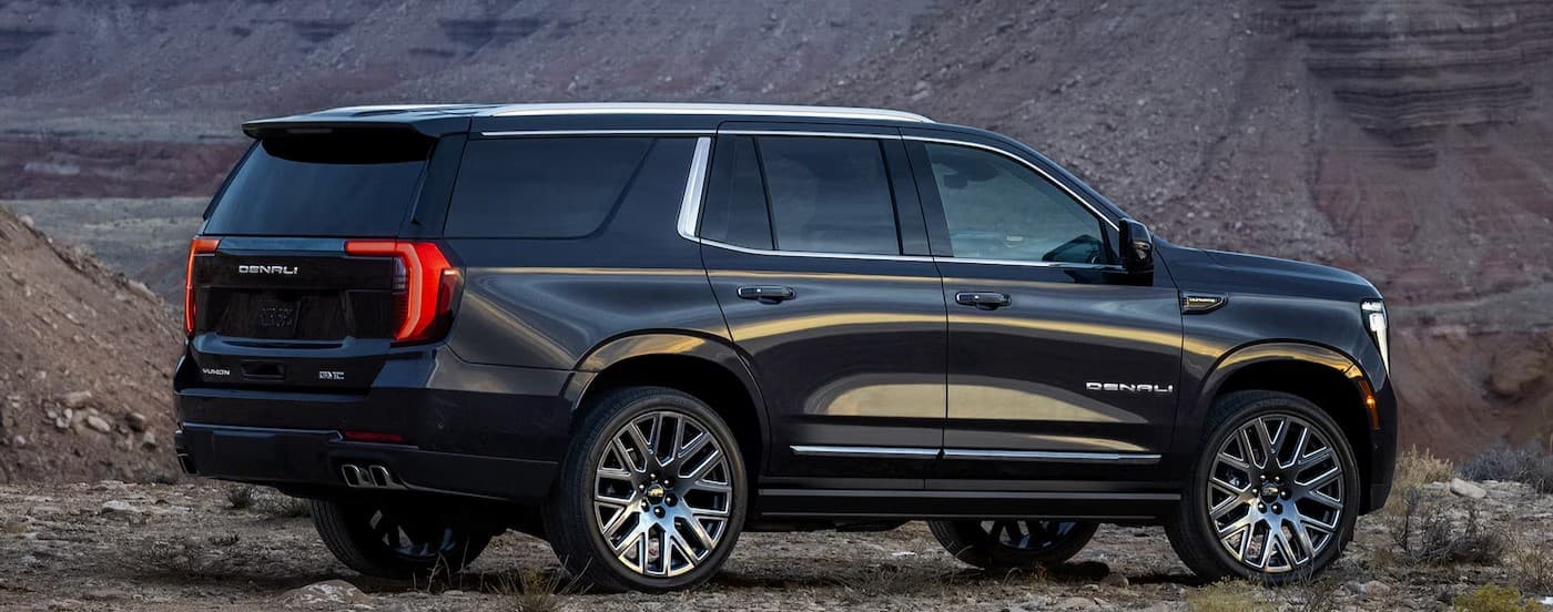 A black 2025 GMC Yukon parked off-road.