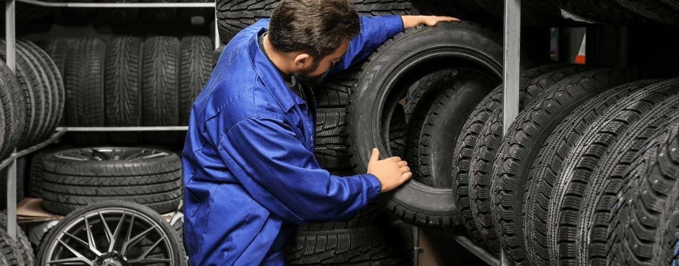 Mechanic picking out a tire from a shelf