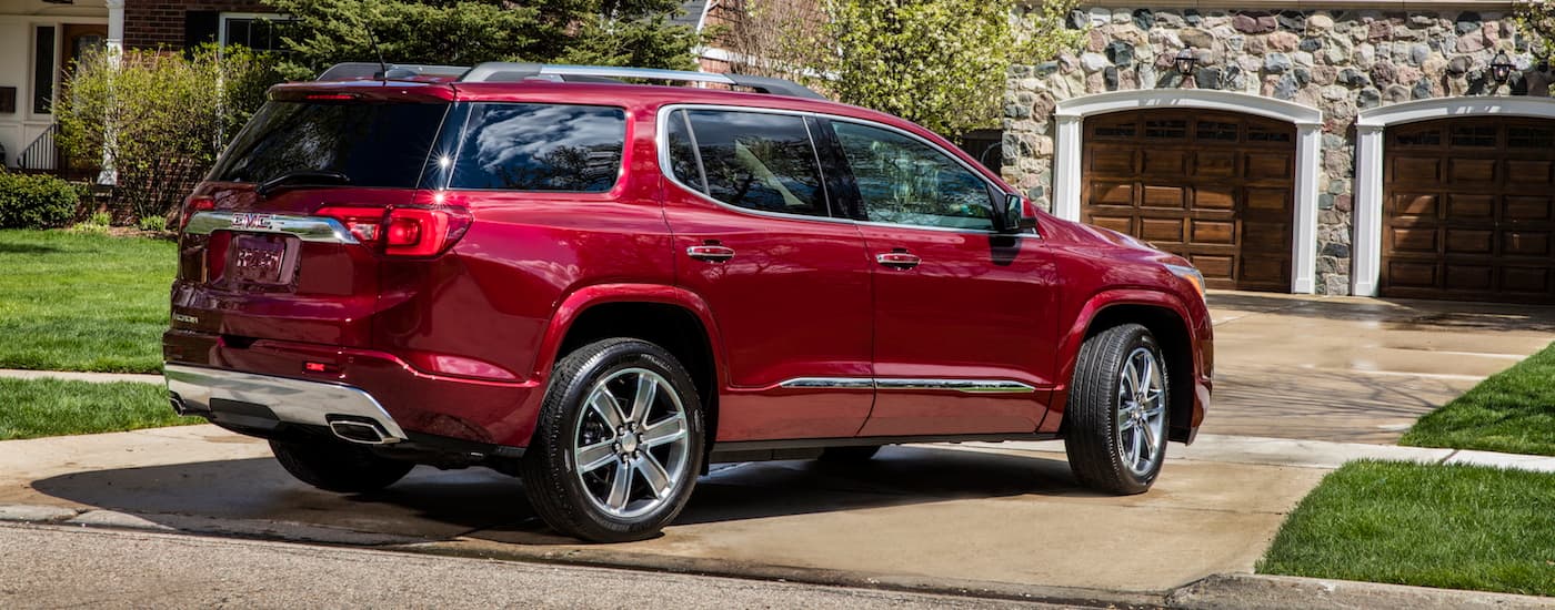 A red 2019 GMC Acadia parked on a driveway.