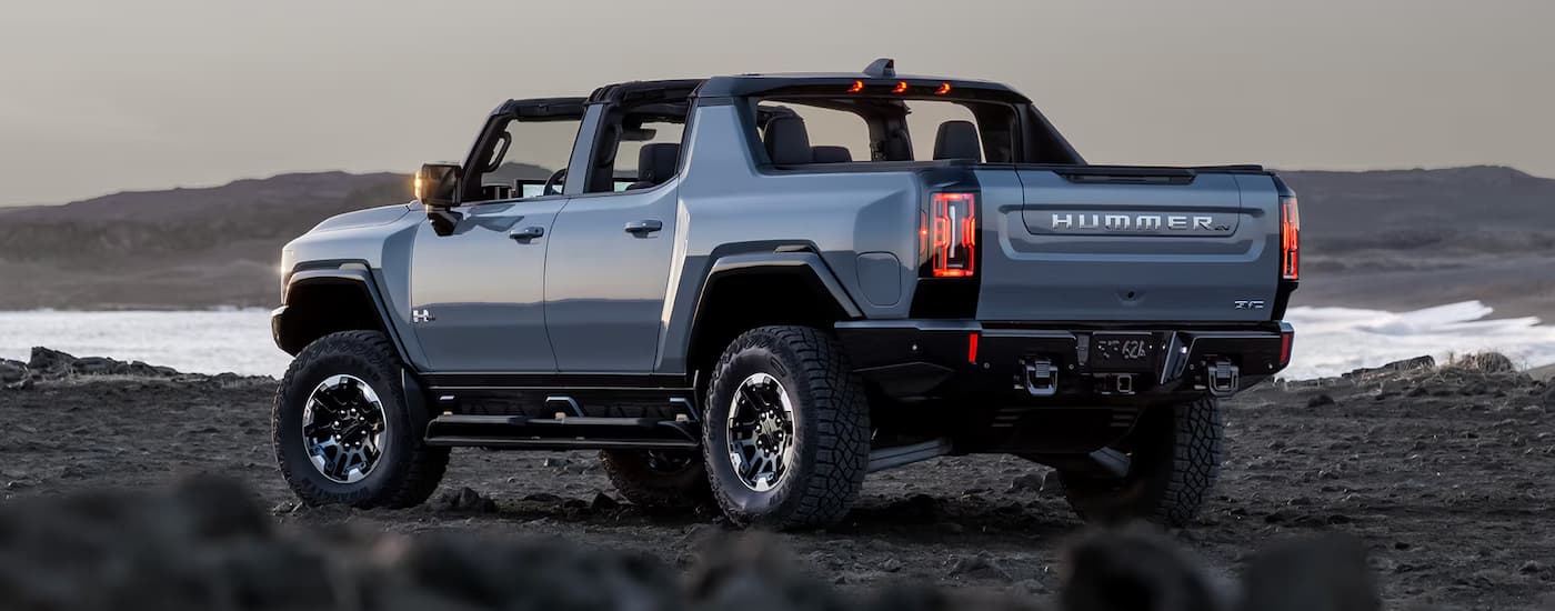 A blue 2025 GMC Hummer EV pickup parked off-road