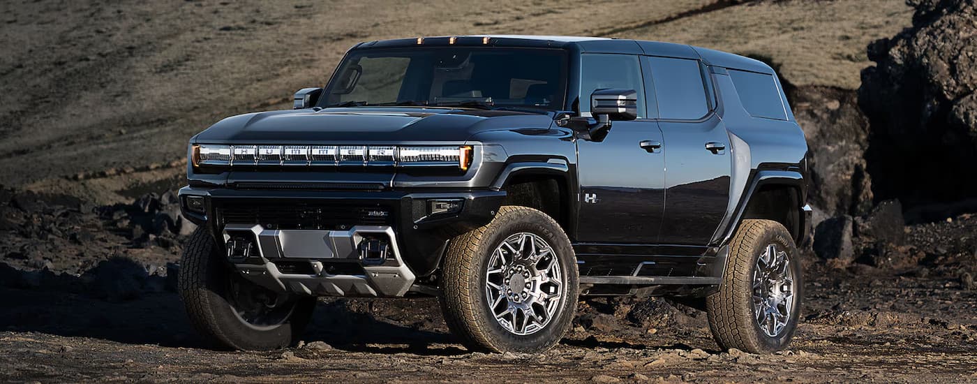A black 2025 GMC Hummer EV SUV parked off-road
